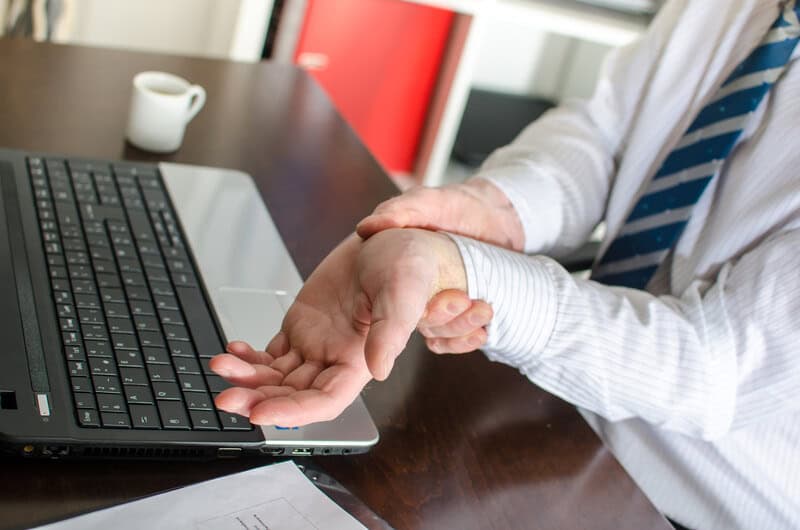 Man with Carpal Tunnel having pain typing on the computer