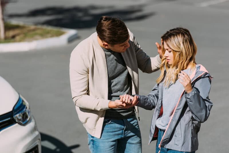 Man Checking On A Woman Who Was Just In A Car Accident