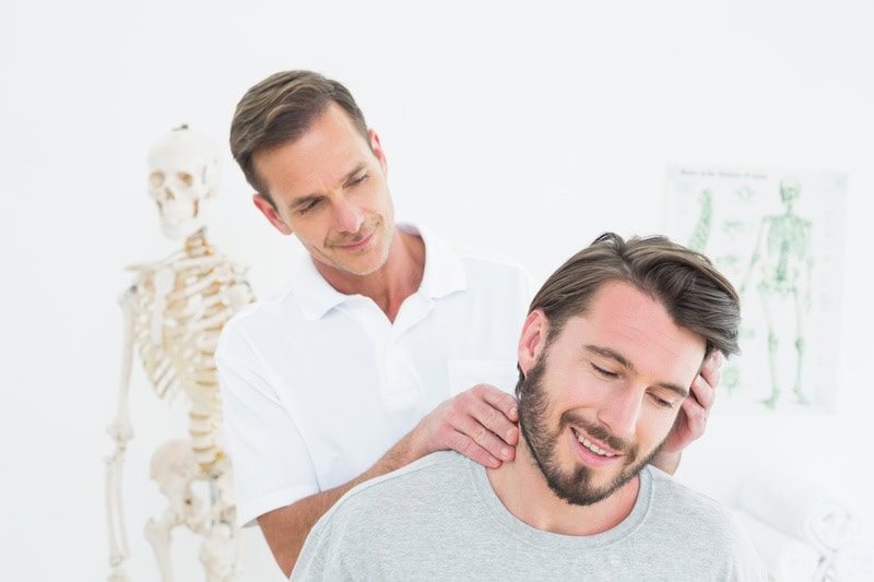 Chiropractor Examining A Patients Neck