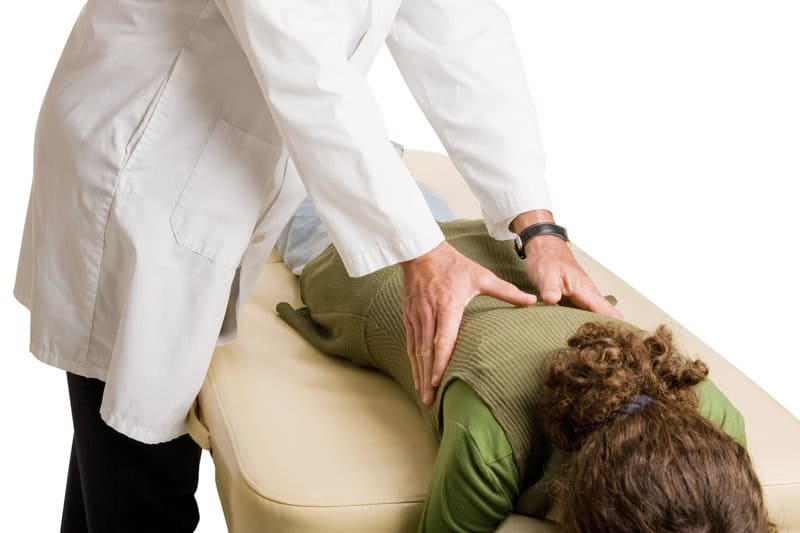 Chiropractor examining a patients back