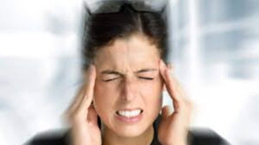 Woman enduring head pain, showing symptoms of a headache or migraine