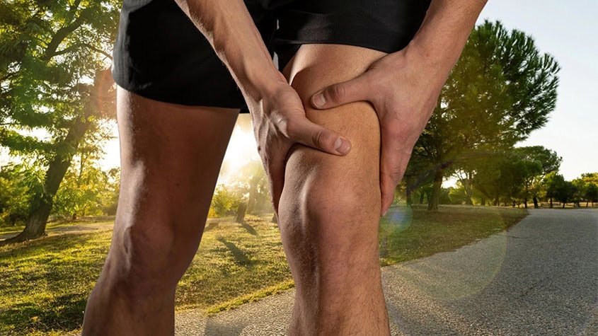 Individual suffering from knee pain in a park