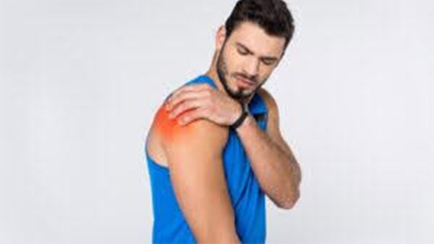 Man experiencing shoulder pain, holding his shoulder with discomfort.