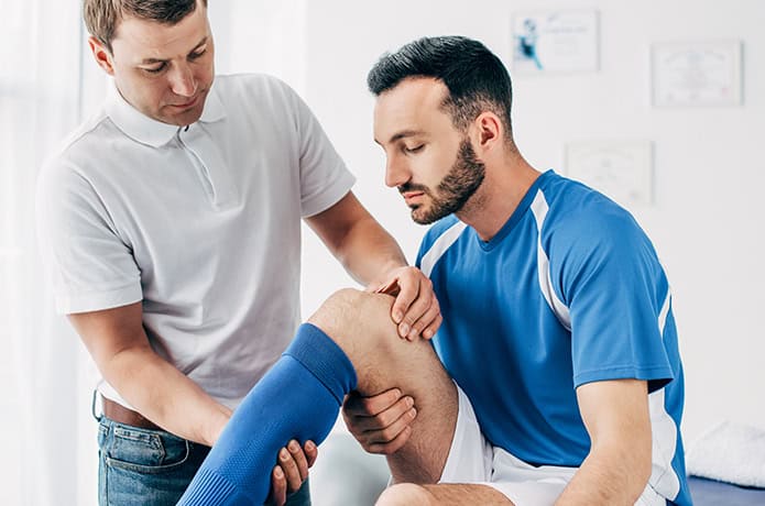 Doctor evaluating Soccer players leg.